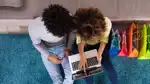 Två ungdomar tittar i en laptop