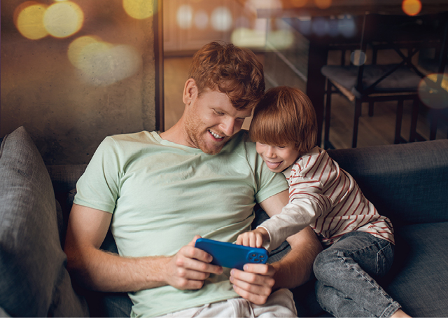 Man och pojke tittar på en mobiltelefon