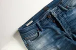 Ett par blåa jeans fickor och gylf.
