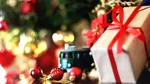 En inslagen julklapp med julbelysning i bakgrunden.