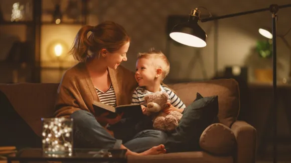 Mor och son sitter i en soffa i ett vardagsrum och ser på varandra.