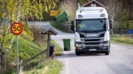 Sopbil med sidlastare tömmer ett sopkärl.