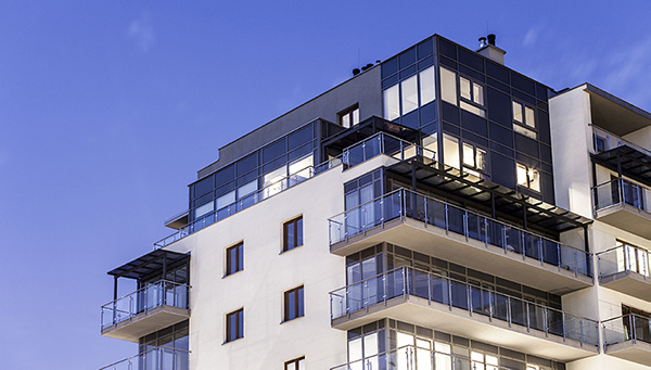 Hyreshusfasad med stora fönster.