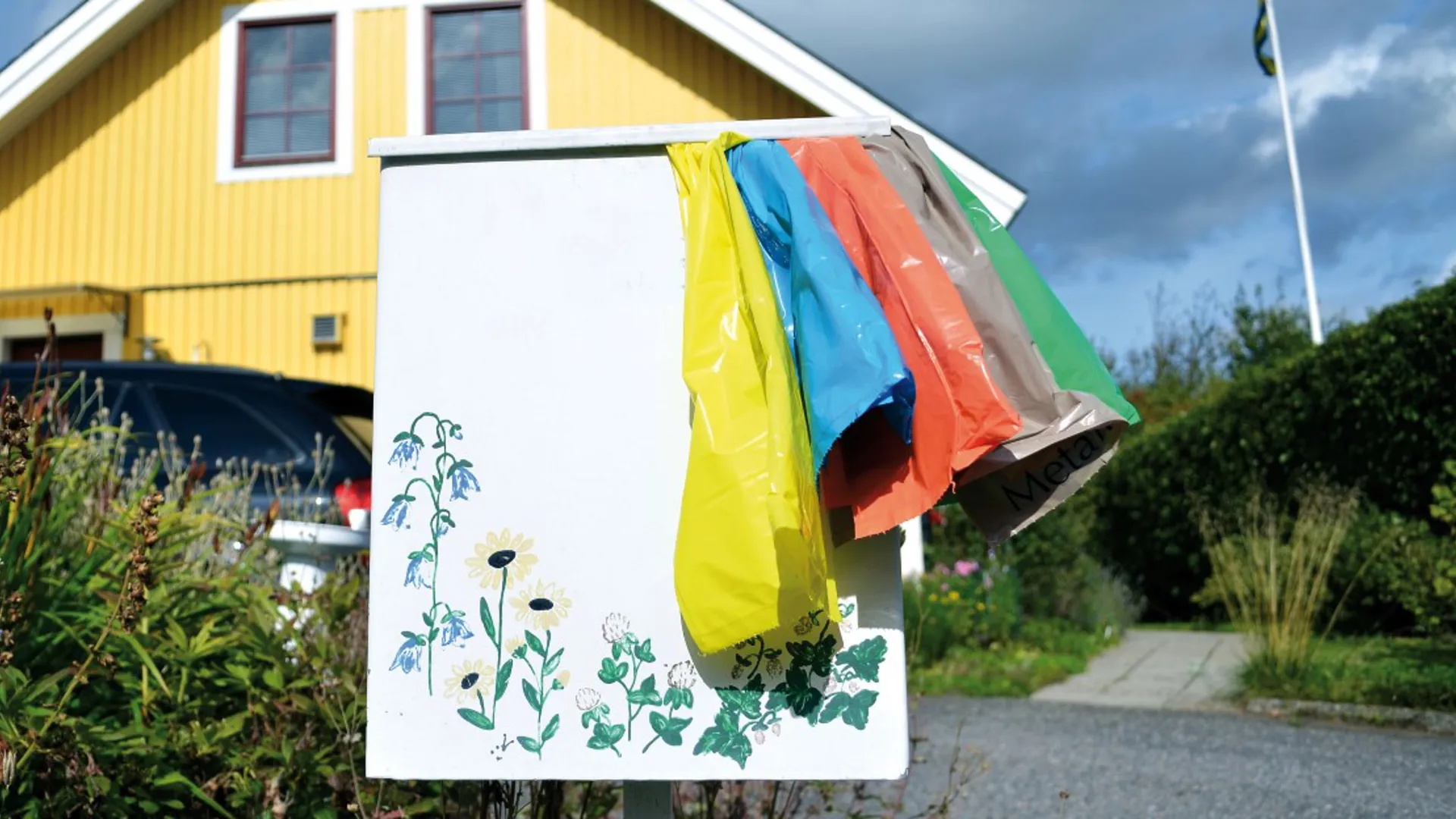 Färgsorteringspåsar som hänger på en postlåda.