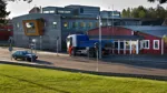 En lastbil står parkerad vid en kontorsbyggnad.