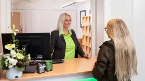 Kundservicemedarbetare hjälper kund vid disk.