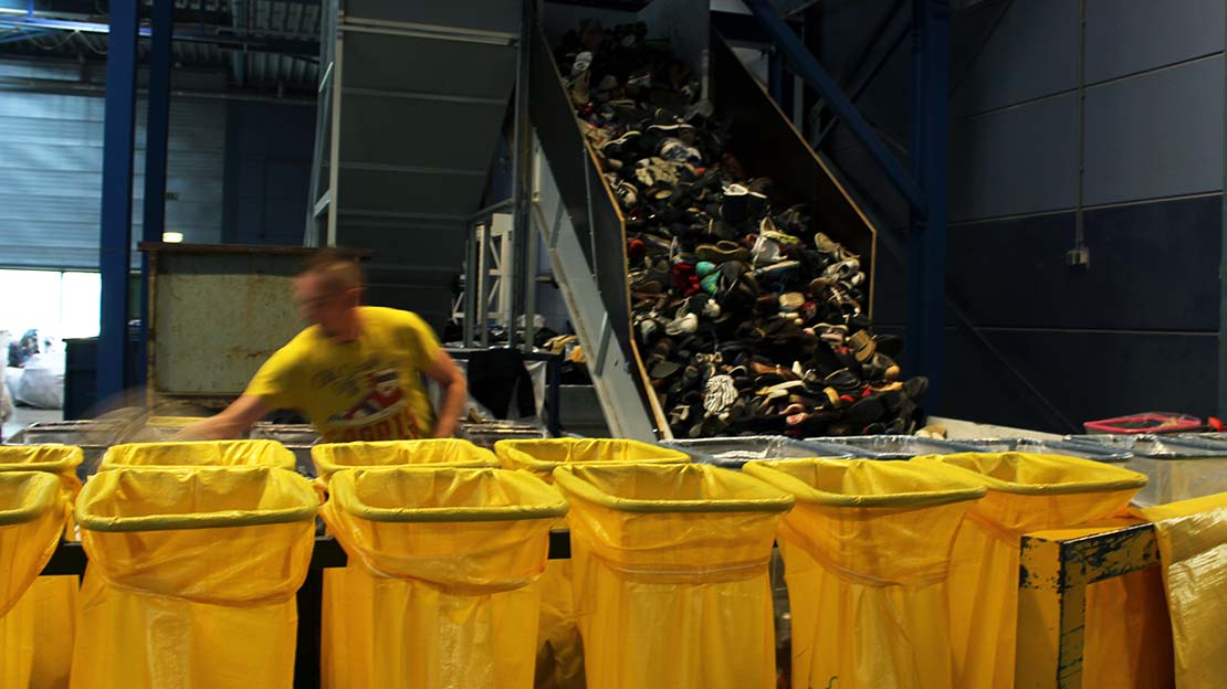 Skor sorteras i återvinningsanläggning.
