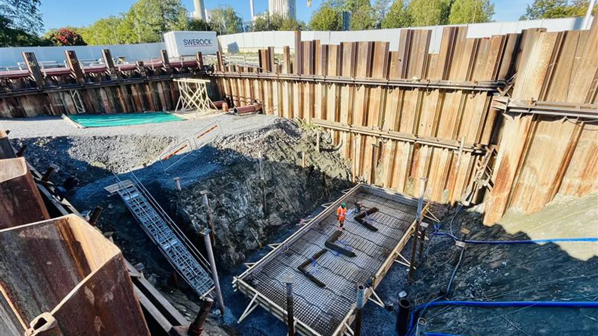10 meter djupt schakt med spontade väggar. En arbetare syns längst ner på botten.