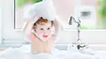 Barn leker med lödder i badkar