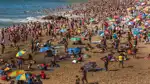 Strand med en massa solbadare