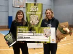 Kimona Hogestadh, ordförande i Eskilstuna Basket, tar emot vinnarchecken från Ulrika Thorén på Eskilstuna Energi och Miljö.