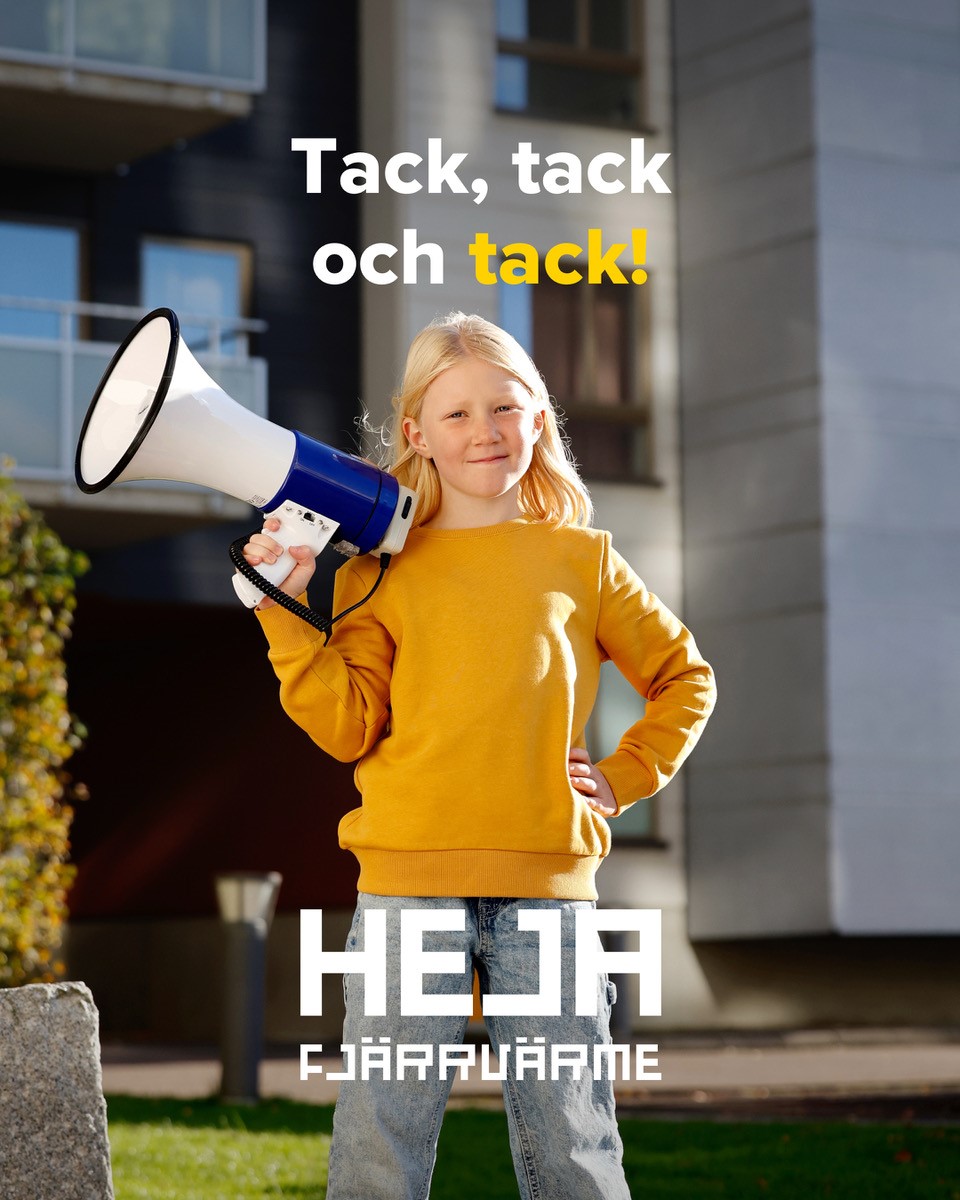 En flicka i gul tröja står framför ett flerbostadshus och håller i en megafon.